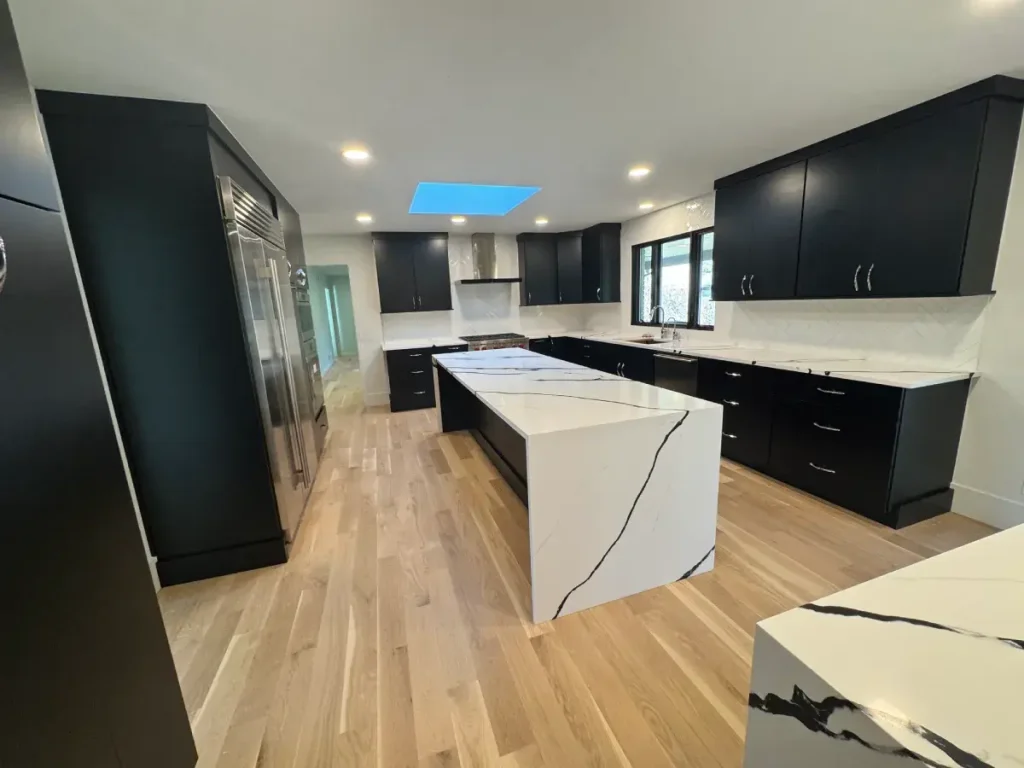 Parker, CO kitchen remodel with black cabinetry, white countertops, and wood flooring
